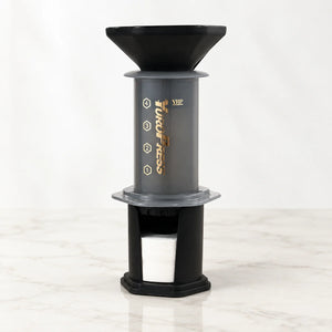 Aeropress Cafeteira YuroPress Cinza montada com funil e porta-filtros sobre bancada clara