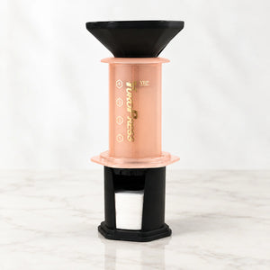 Aeropress Cafeteira YuroPress Laranja montada com funil e porta-filtros sobre bancada clara