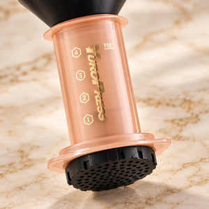 Detalhe da câmara laranja translúcida e da tampa perfurada da Aeropress Cafeteira YuroPress Laranja