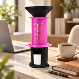 Aeropress Cafeteira YuroPress Rosa ao lado de notebook, caderno e caneca de café