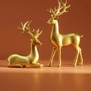 Par de renas decorativas na cor dourado, uma em pé e outra deitada