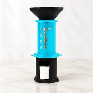 Aeropress Cafeteira YuroPress Azul montada com funil e porta-filtros sobre bancada clara