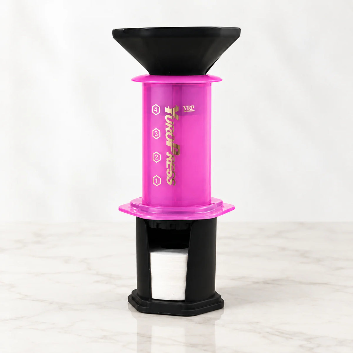 Aeropress Cafeteira YuroPress Rosa montada com funil e porta-filtros sobre bancada clara