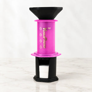 Aeropress Cafeteira YuroPress Rosa montada com funil e porta-filtros sobre bancada clara