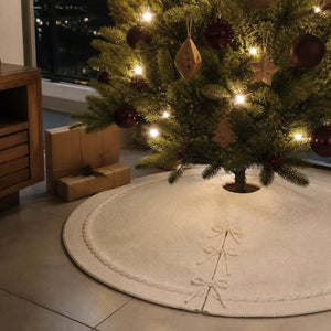 Saia de Natal branca tricotada sob árvore iluminada em piso de porcelanato