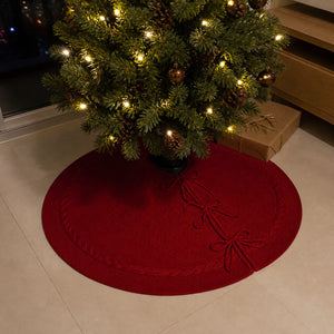 Saia de Natal vermelha tricotada sob árvore iluminada em piso de porcelanato