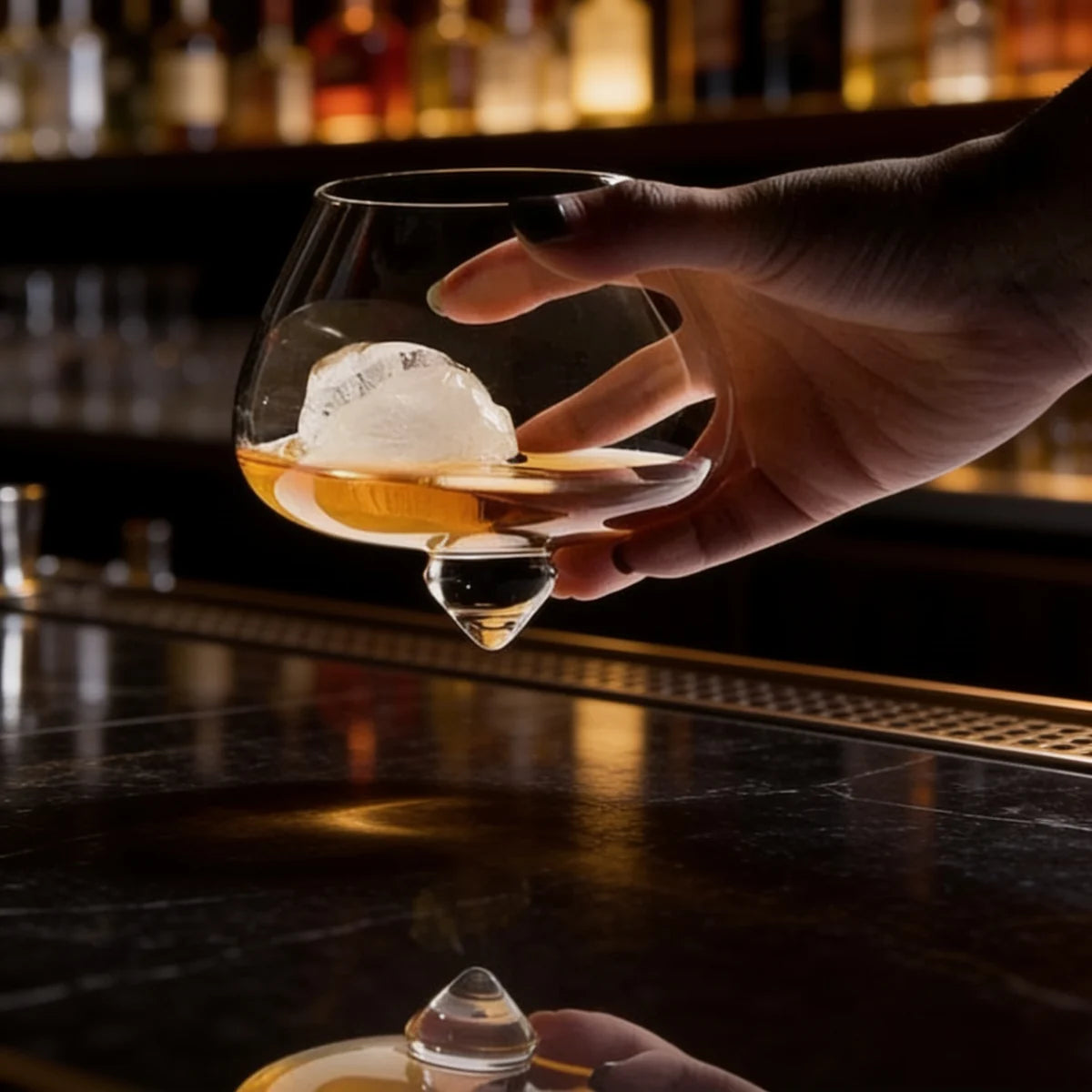 Copo de whisky cristal base rotativa Lumi Homi em uso com gelo