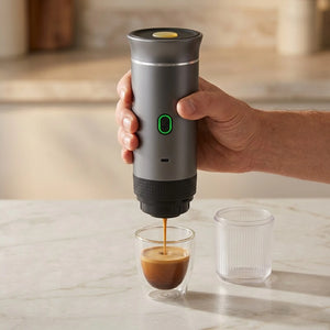 Cafeteira portatil cinza extraindo espresso em copo pequeno