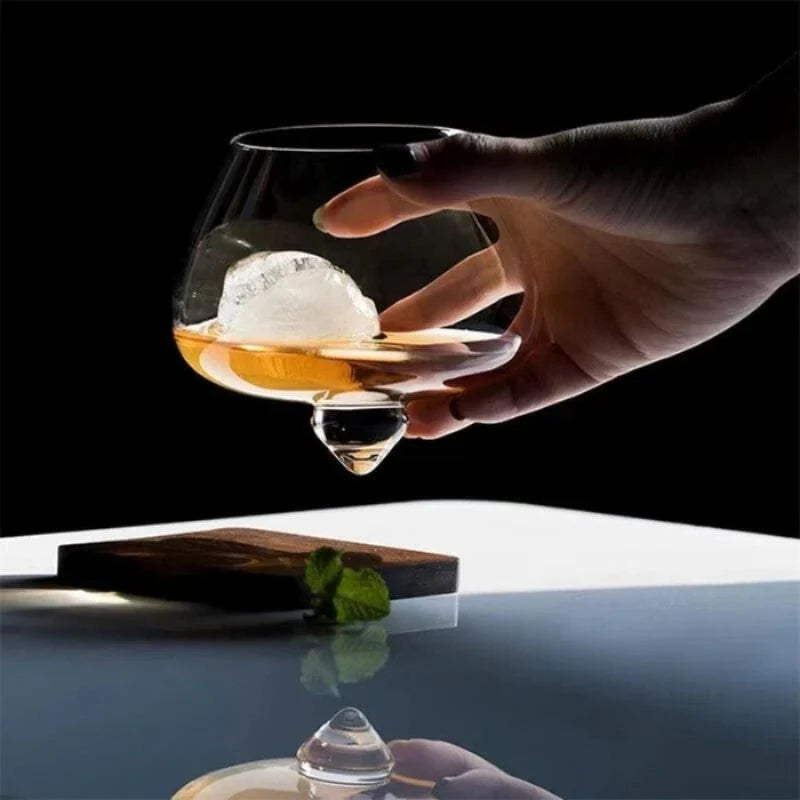 Copo de whisky cristal base rotativa Lumi Homi em escala na mao