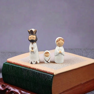 Três figuras do Presépio de Natal Mini sobre livros para referência de escala