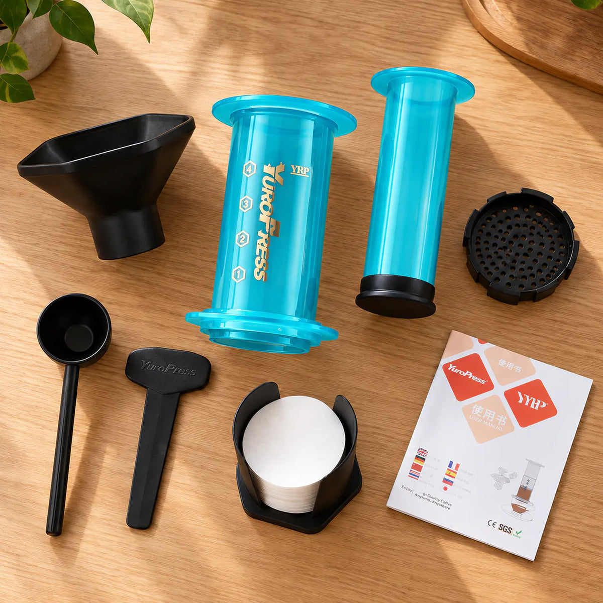Peças e acessórios da Aeropress Cafeteira YuroPress Azul organizados sobre uma bancada de madeira