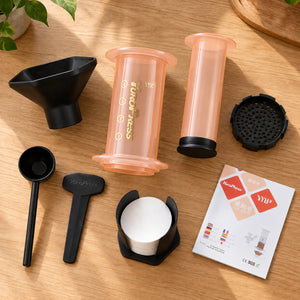 Peças e acessórios da Aeropress Cafeteira YuroPress Laranja organizados sobre uma bancada de madeira