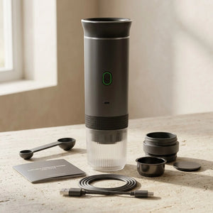 Cafeteira portatil cinza com cabo USB-C e acessorios apoiados