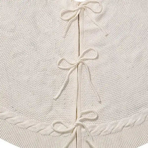 Detalhe da trama e dos laços da saia para árvore de Natal tricotada branca