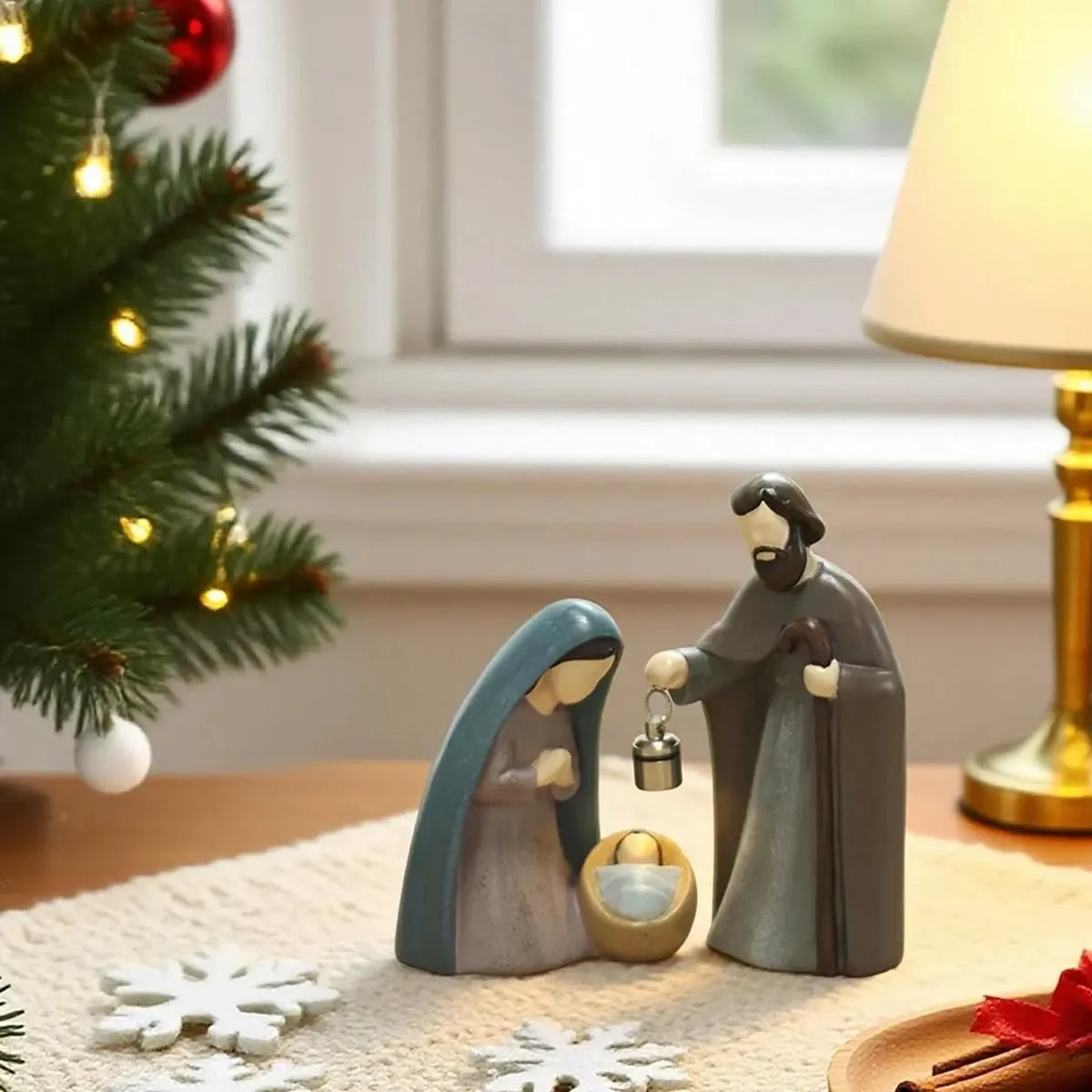 Presépio de Natal Iluminado sobre mesa ao lado da árvore decorada