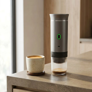 Cafeteira portatil cinza ao lado de espresso pronto na xicara
