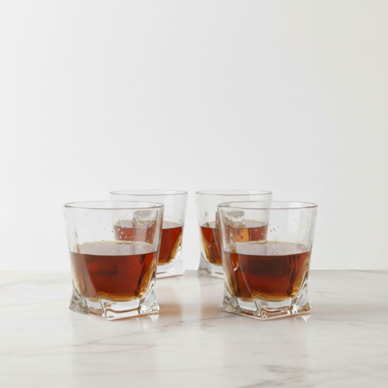 Kit com 4 copos de whisky cristal Twist Lumi Homi com bebida ambar