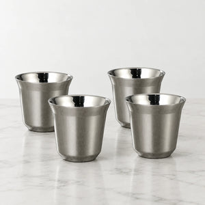 Conjunto de quatro xícaras de café inox cinza Lumi Homi, com acabamento prateado acetinado e interior polido, sobre bancada clara