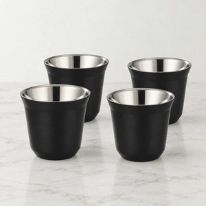Conjunto de quatro xícaras de café inox preto Lumi Homi, vazias, com interior metálico sobre bancada clara